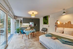 une chambre avec un lit et une table dans une pièce dans l'établissement Studio LILAS avec terrasse au calme, à Montreuil 3 autres photos