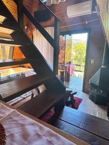 a wooden staircase in a room with a bed at Chalé Aconchego Alfredo Wagner in Alfredo Wagner