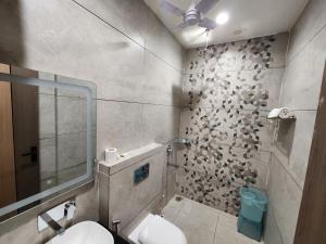 a bathroom with a sink and a toilet in it at Den Inn in Hisār