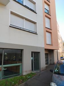 een appartementencomplex met een auto ervoor geparkeerd bij Studio centre Rouen rive gauche au pied du T4 in Le Petit-Quevilly