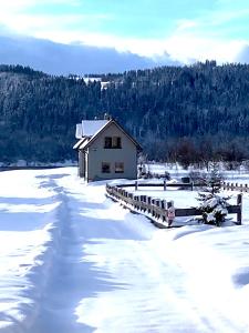 a house in the snow next to a snow covered field at Ciche Pole in Maniowy