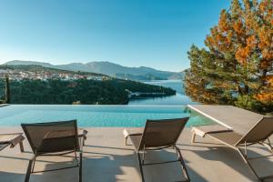two chairs and a table with a view of a lake at Kohyli Villas in Meganisi