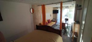 a bedroom with a bed and a room with a window at Studio La Cheneraie in Bargemon