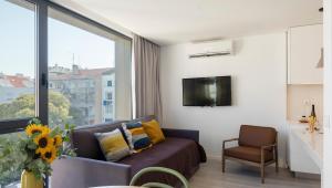 een woonkamer met een bank en een groot raam bij Lisbon Serviced Apartments - Parque in Lissabon