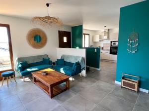 ein Wohnzimmer mit blauen Stühlen und einem Tisch in der Unterkunft Résidence du Moulin Girard in Jard-sur-Mer