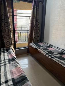 a bedroom with two beds and a window in a room at Riyas stay in Mumbai +6 photos