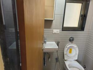a small bathroom with a toilet and a sink at Riyas stay in Mumbai