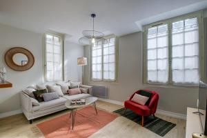 - un salon avec un canapé et un fauteuil rouge dans l'établissement L' Harmonie, à Périgueux