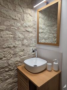 ein Badezimmer mit einem Waschbecken und einer Steinmauer in der Unterkunft Studio 2 personnes proche du Futuroscope in Beaumont + 9 Fotos