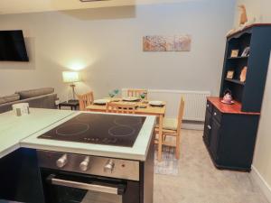 a kitchen and living room with a stove and a table at 20 Lorton Street in Cockermouth