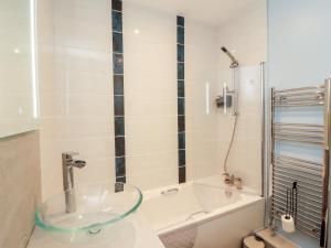 a bathroom with a glass sink and a bath tub at 20 Lorton Street in Cockermouth +18 photos