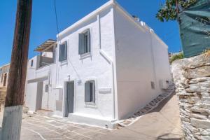 a white building with a door on the side of it at Suite Amalaya Κατώι in Kithnos