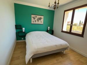 ein Schlafzimmer mit einem Bett und einer grünen Wand in der Unterkunft Résidence du Moulin Girard in Jard-sur-Mer