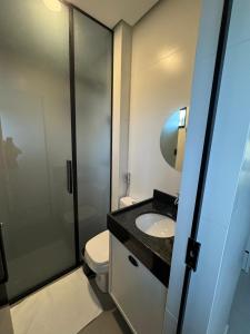 a bathroom with a toilet and a sink and a shower at Flat Bugayalê Lounge in Garanhuns