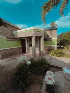 a house with a building with a bench in front of it at Complejo La Yema in Miramar