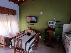 a kitchen and dining room with a table and a television at Arevalo Mar de Ajo in Mar de Ajó