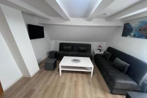 ein Wohnzimmer mit Sofa und Tisch in der Unterkunft Team at Home Gemütliches Dachgeschossapartment in Blaubeuren
