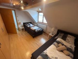 ein kleines Schlafzimmer mit einem Bett und einem Fenster in der Unterkunft Team at Home Gemütliches Dachgeschossapartment in Blaubeuren