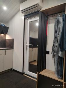 a room with a door to a kitchen with a mirror at Gästehaus "Säntis" in Carnikava