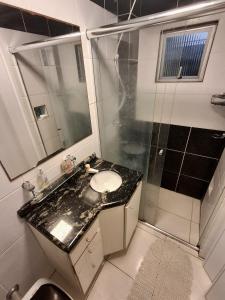 a bathroom with a sink and a shower at Cantinho da Ro in Balneário Camboriú