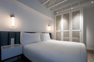 a large white bed in a room with a window at Tandem Mezquita in Córdoba