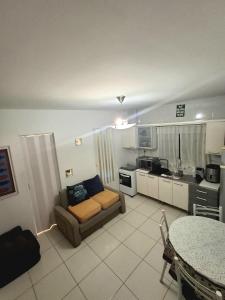 a living room with a couch and a kitchen at Cantinho da Ro in Balneário Camboriú