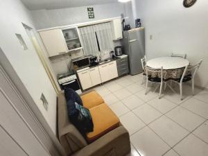 a living room and kitchen with a couch and a table at Cantinho da Ro in Balneário Camboriú +7 photos