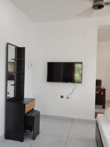 a living room with a tv on a white wall at VLand homestay in Vagamon