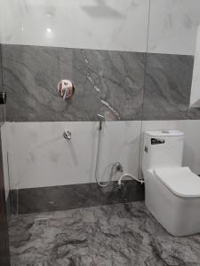 a bathroom with a toilet and a valve on the wall at VLand homestay in Vagamon +9 photos