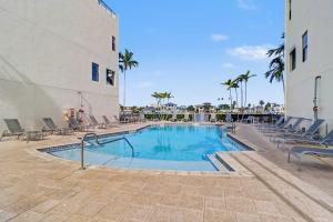 een zwembad met stoelen en een gebouw bij BrightWater Blue 158-2 in Clearwater Beach