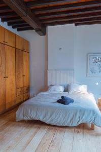a bedroom with a large bed with a blue blanket at De Wijngaard in Ghent