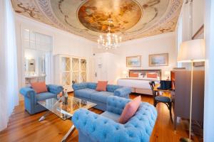 een woonkamer met blauwe banken en een slaapkamer bij Once Upon Lisboa in Lissabon
