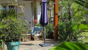 een parasol en een stoel op een patio bij Ti kaz cheu nous in Saint-Louis