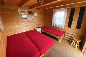 een kamer met een rood bed in een blokhut bij Blockhütte am Flugplatz mit Pool in Kühndorf