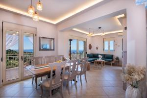 a dining room and living room with a table and chairs at Great Escape Sea View Private Pools, Jacuzzi & Ultimate Relaxation in Maroulás +201 photos