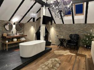 a bathroom with a white tub and a table and chair at Relax in Style Boutique Hotel in Braşov