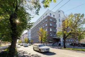 an old car is driving down a city street at Balcia Residence in Riga
