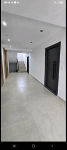 een grote, lege kamer met een deur en een trap bij Aerodrom apartman in Ledine