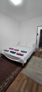 een bed op een tapijt in een kamer bij Aerodrom apartman in Ledine