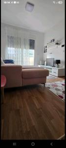 een woonkamer met een grote bank in een kamer bij Aerodrom apartman in Ledine