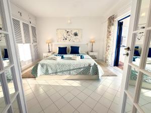 a bedroom with a large bed with blue pillows at WindMill Rooftop Panoramic OceanView Condo By BeCherish in Albufeira +49 photos
