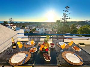 a table with food and drinks on a balcony at WindMill Rooftop Panoramic OceanView Condo By BeCherish in Albufeira
