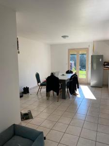 a living room with a table and chairs and a kitchen at Chambre de maison de campagne in Uzerche