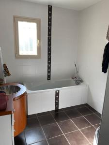 a bathroom with a bath tub and a sink at Chambre de maison de campagne in Uzerche