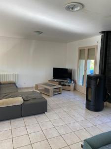 a living room with a bed and a flat screen tv at Chambre de maison de campagne in Uzerche