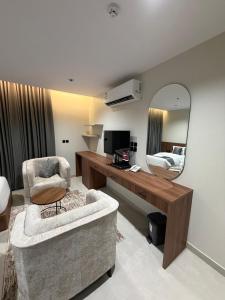een woonkamer met een stoel en een spiegel bij ديار الاسترخاء للشقق المخدومة in Najran