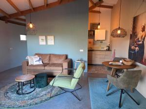 a living room with a couch and a table at Hoeve H-art, Silo 161, Uniek Drents silo-appartement met privé terras en rust in Ruinerwold