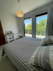 een slaapkamer met een bed en een groot raam bij Balcón Andino in Maipú