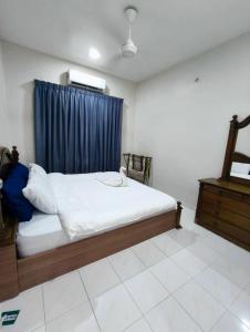 a bedroom with a bed with a blue curtain at Homestay Melaka Baitul Saadah in Malacca +4 photos