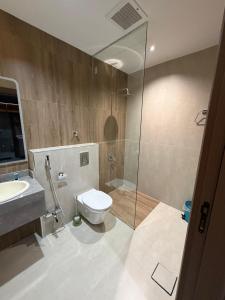 een badkamer met toilet, douche en wastafel bij ديار الاسترخاء للشقق المخدومة in Najran